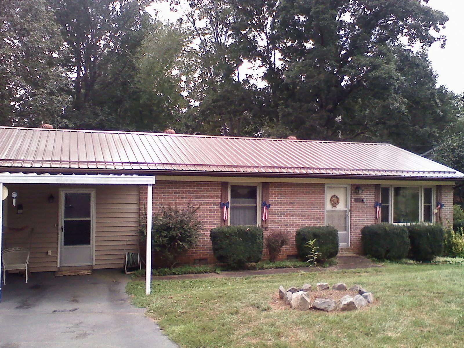Bronze metal roof and carport on a brick ranch home — Roof Repair work by our crew in Kingstree